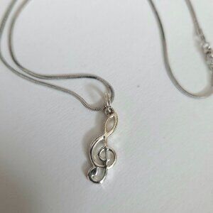 Silver color treble clef pendant.